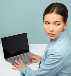 Contracting for Online Therapy - privacy and confidentiality Contracting for Online Therapy - woman in front of her laptop looks over her shoulder to ensure privacy