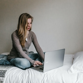 What is Online Counselling and Psychotherapy? - woman typing on laptop in bed What is Online Counselling and Psychotherapy? - A woman typing on her laptop in bed. With email counselling, a person can receive help without leaving their home